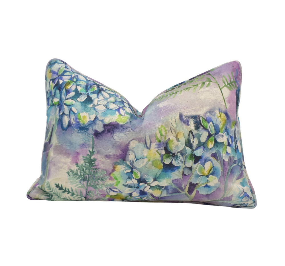 a decorative pillow with a vibrant floral pattern in shades of blue, purple, and green.