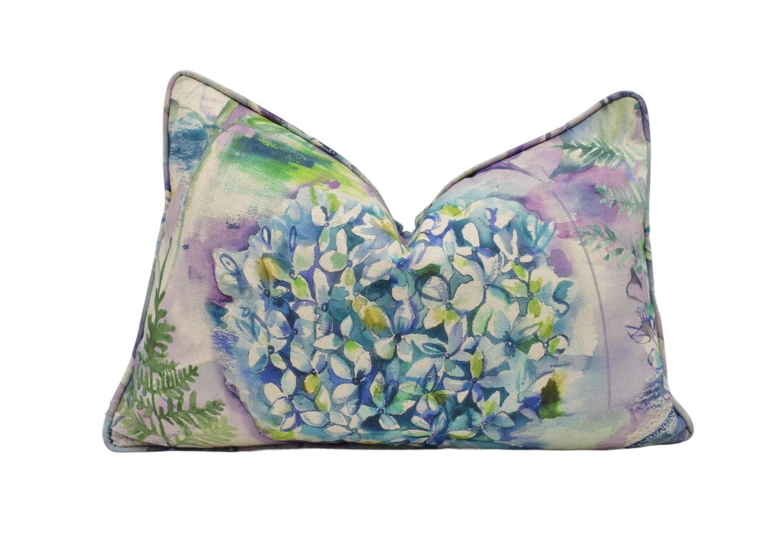 a decorative pillow with a vibrant floral pattern in shades of blue, green, and purple.