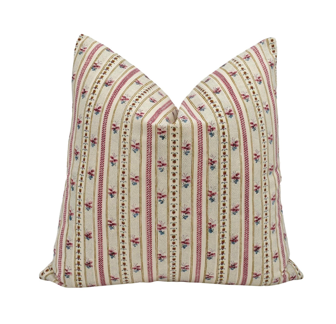 A decorative pillow with a floral pattern in shades of pink and beige.