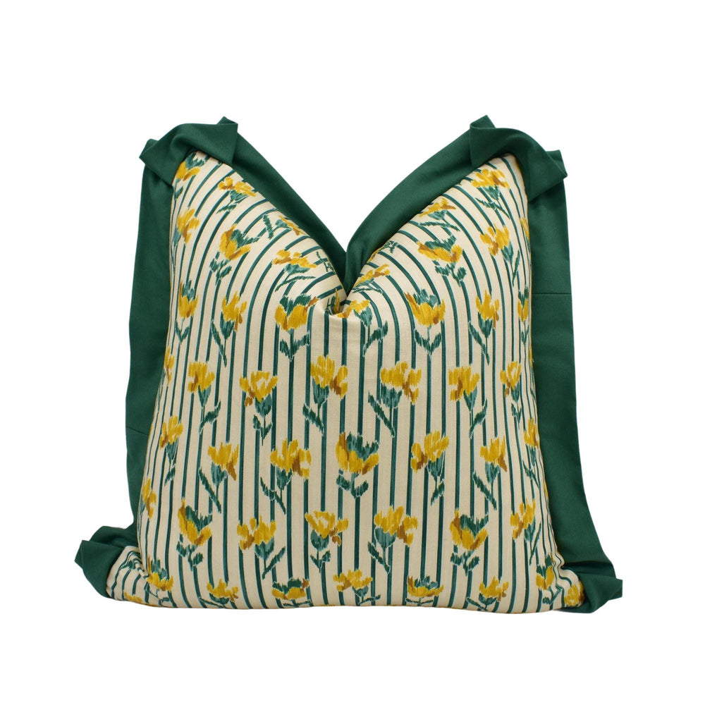 A decorative pillow with a floral pattern in shades of green and yellow.