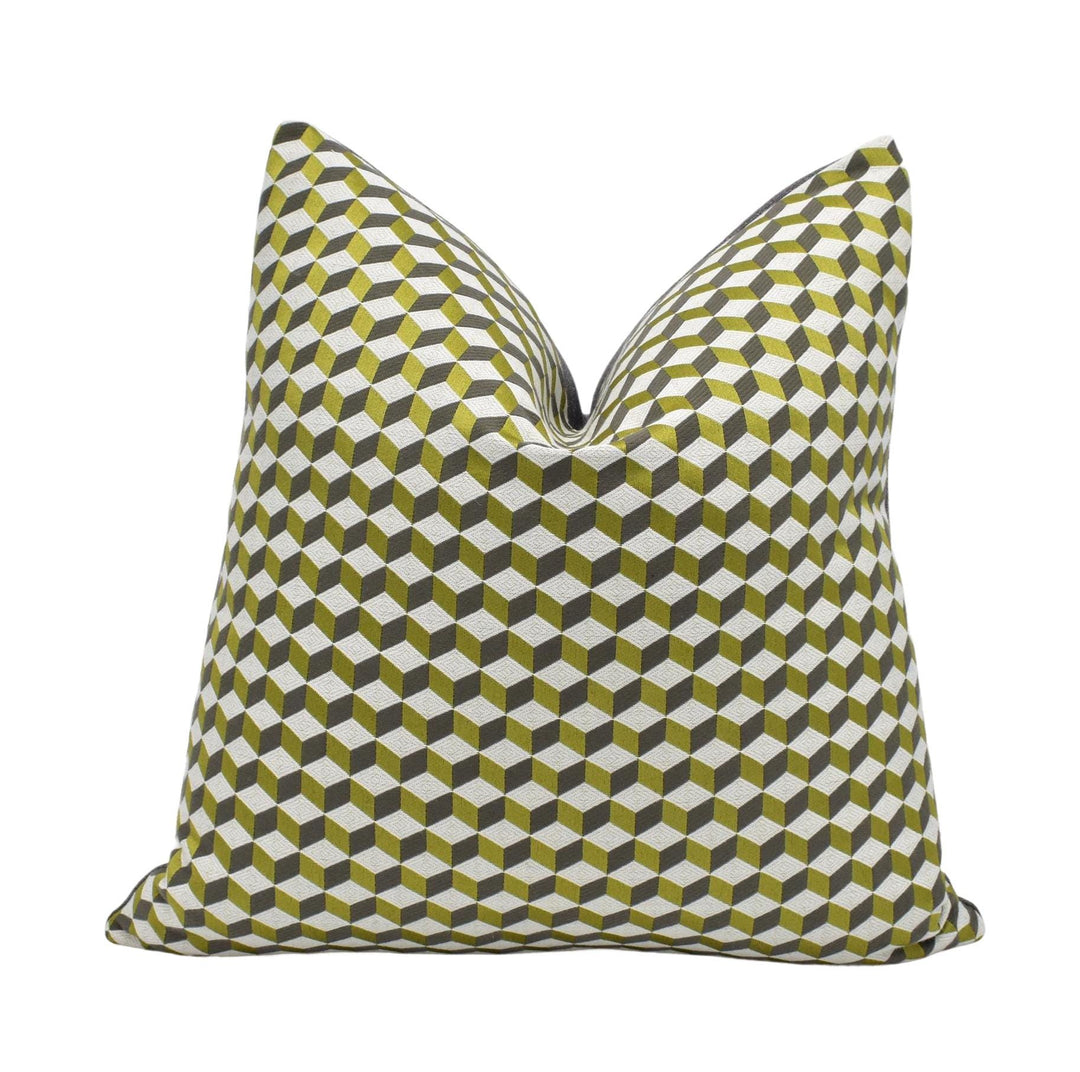 a square pillow with a geometric pattern of green and white cubes.