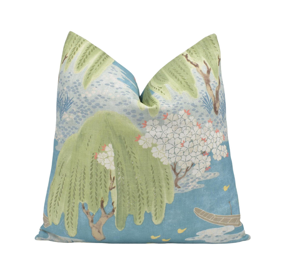 a blue and green pillow with a whimsical, nature-inspired design.