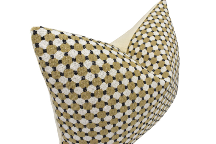 a close-up view of a decorative pillow with a geometric pattern of black and white dots.