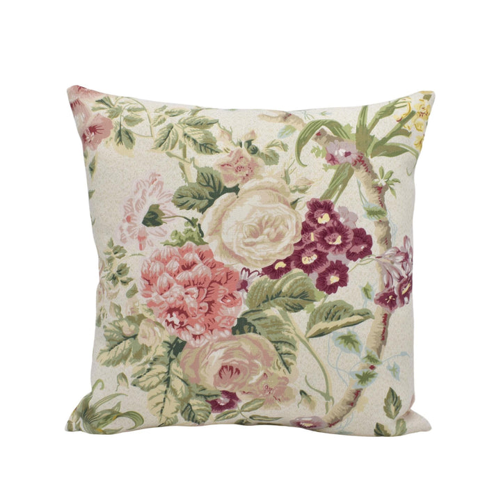 A decorative throw pillow with a floral print featuring various pink, white, and purple flowers and leaves.