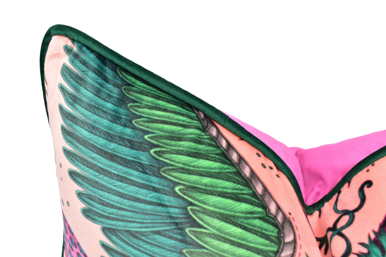 a close up of a pink and green pillow with wings on it