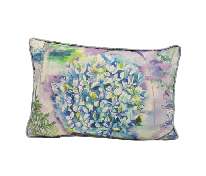 A decorative pillow with a floral print featuring blue and green flowers.