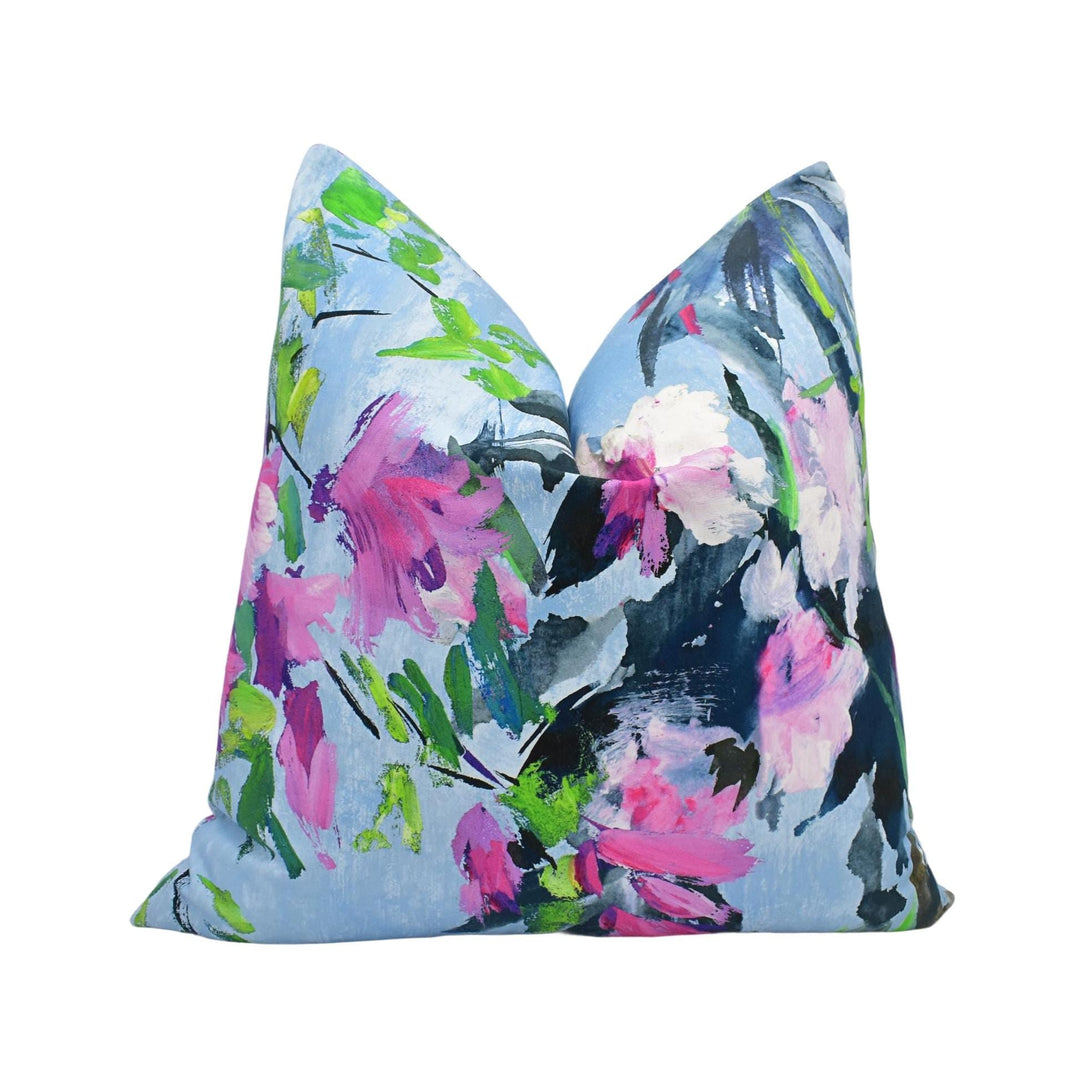 a blue pillow with pink flowers on it