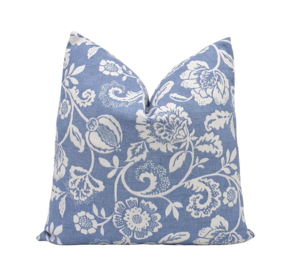 a blue pillow with white flowers on it