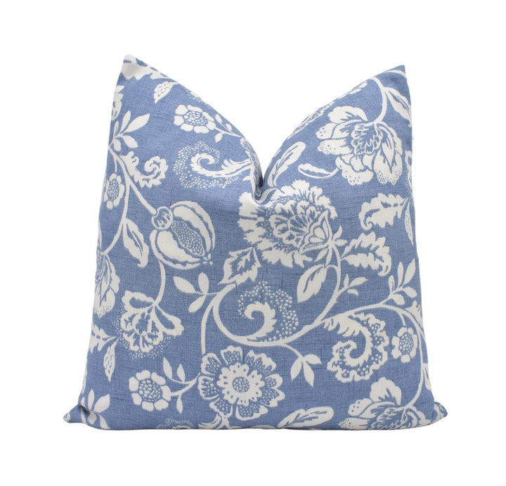 a blue pillow with white flowers on it