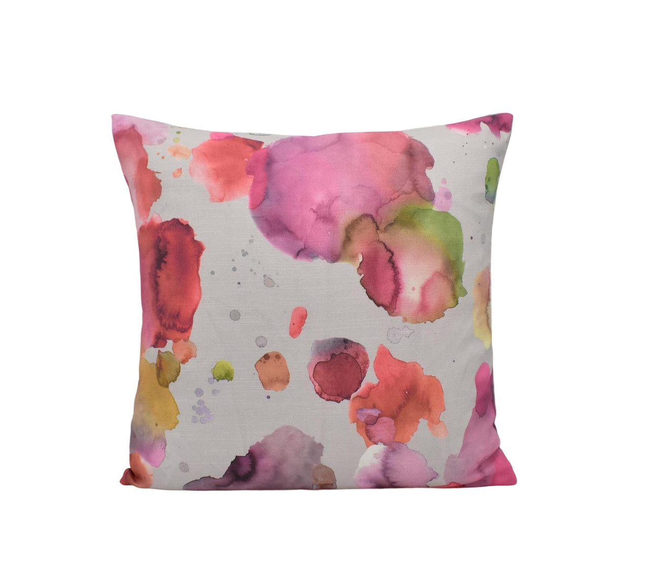 a white pillow with pink and green paint splattered on it