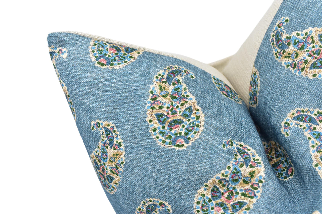 a close up of a blue pillow with a paisley pattern