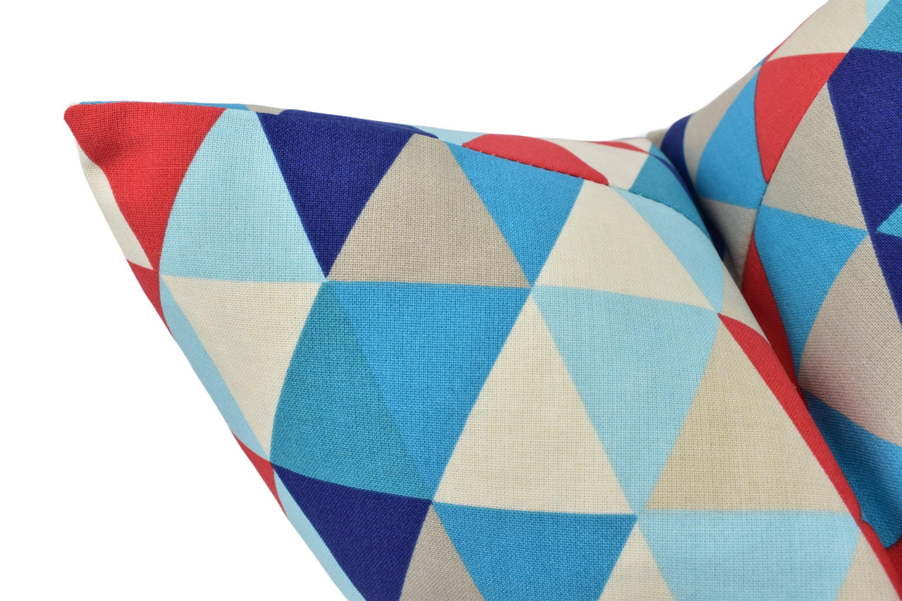 a blue, red, and white pillow with a triangle pattern