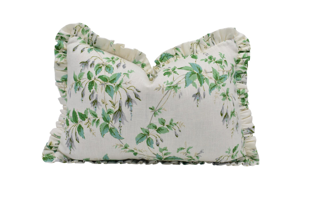 a white pillow with green leaves on it