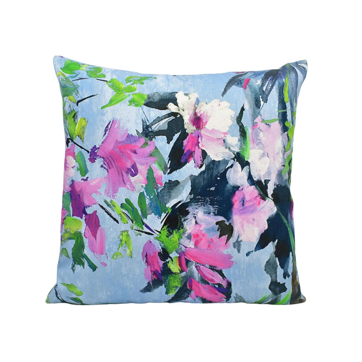 a blue pillow with pink and white flowers on it