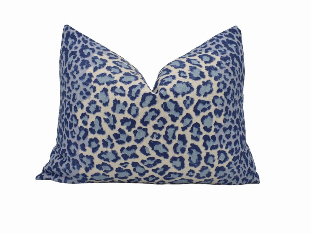a blue and white leopard print pillow on a white background