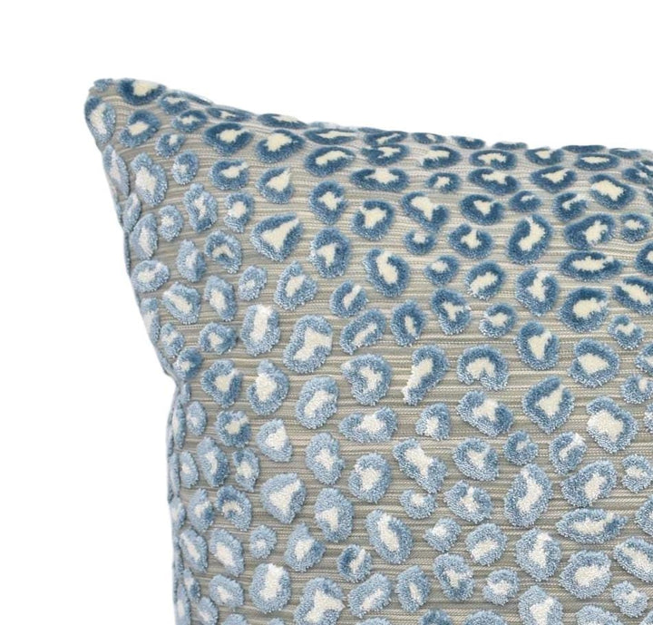 a blue and white pillow on a white background