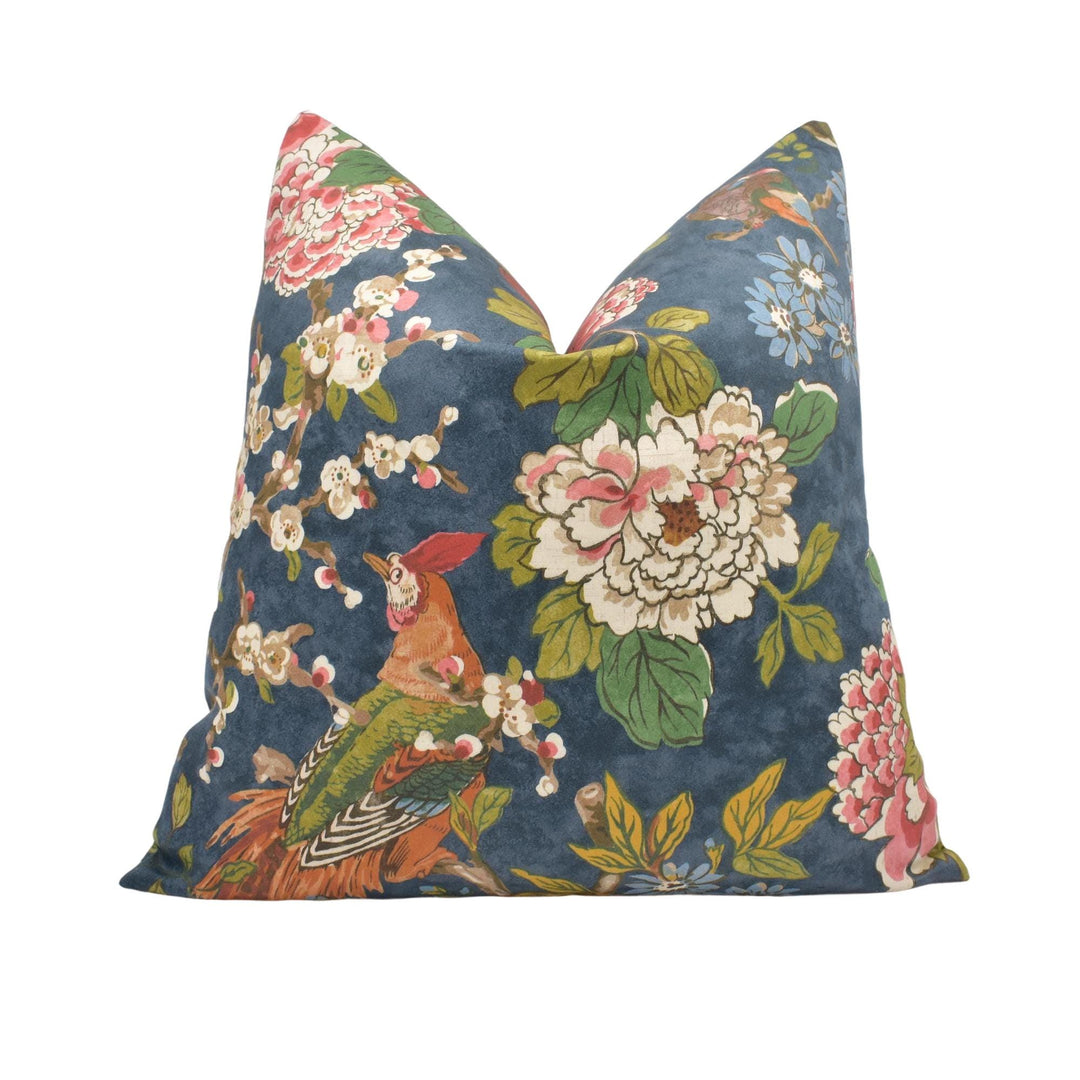 a blue pillow with flowers and birds on it