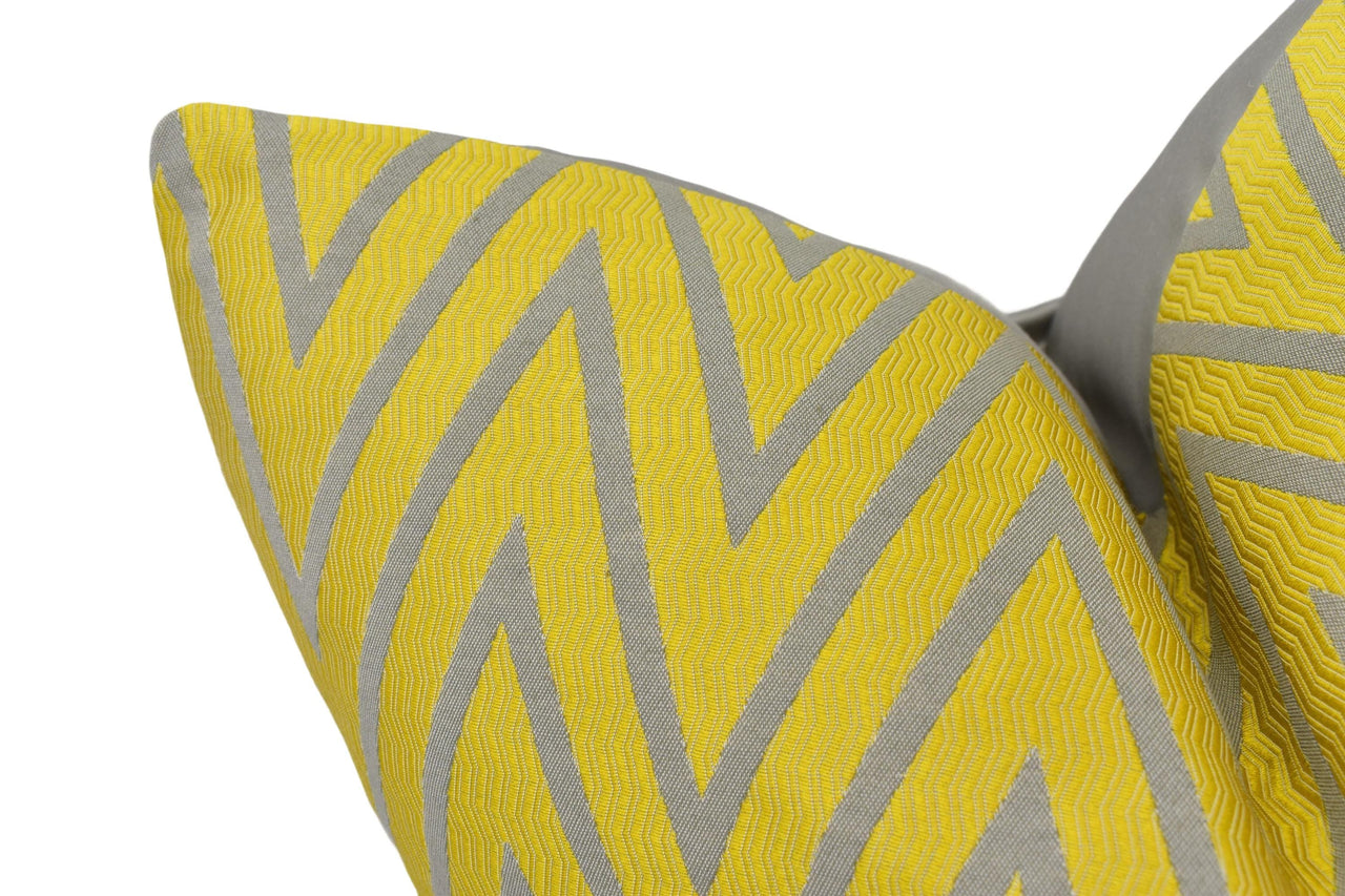 a close up of a yellow and grey pillow