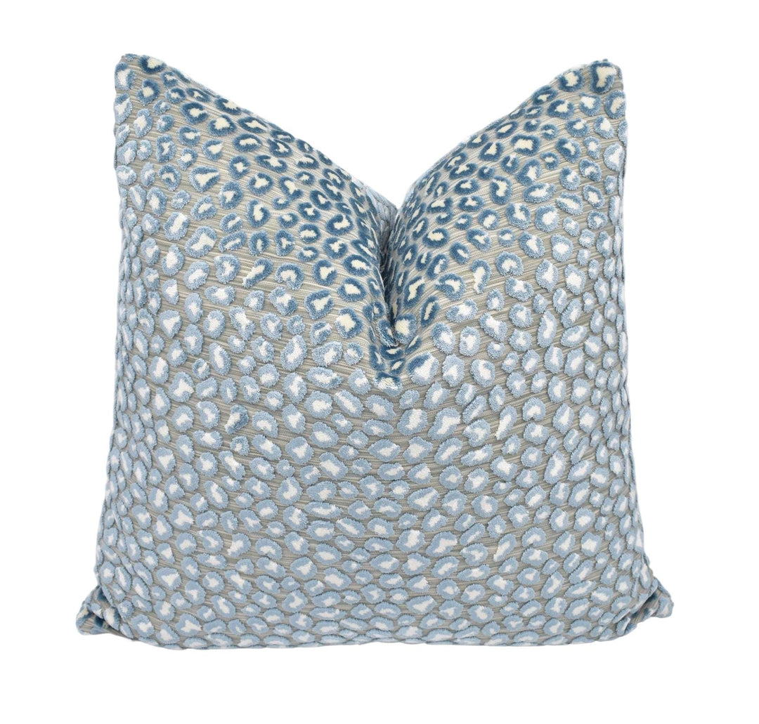 a blue and white pillow on a white background