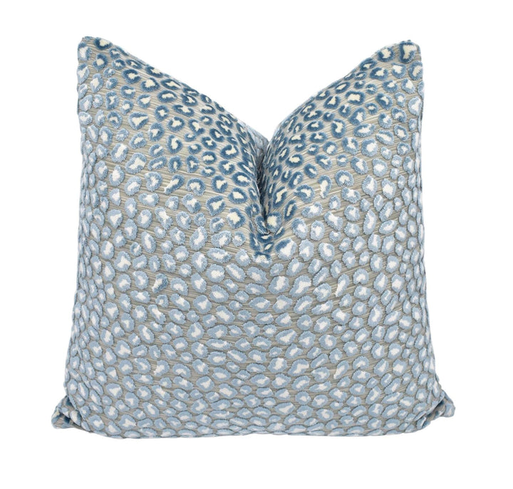 a blue and white pillow on a white background