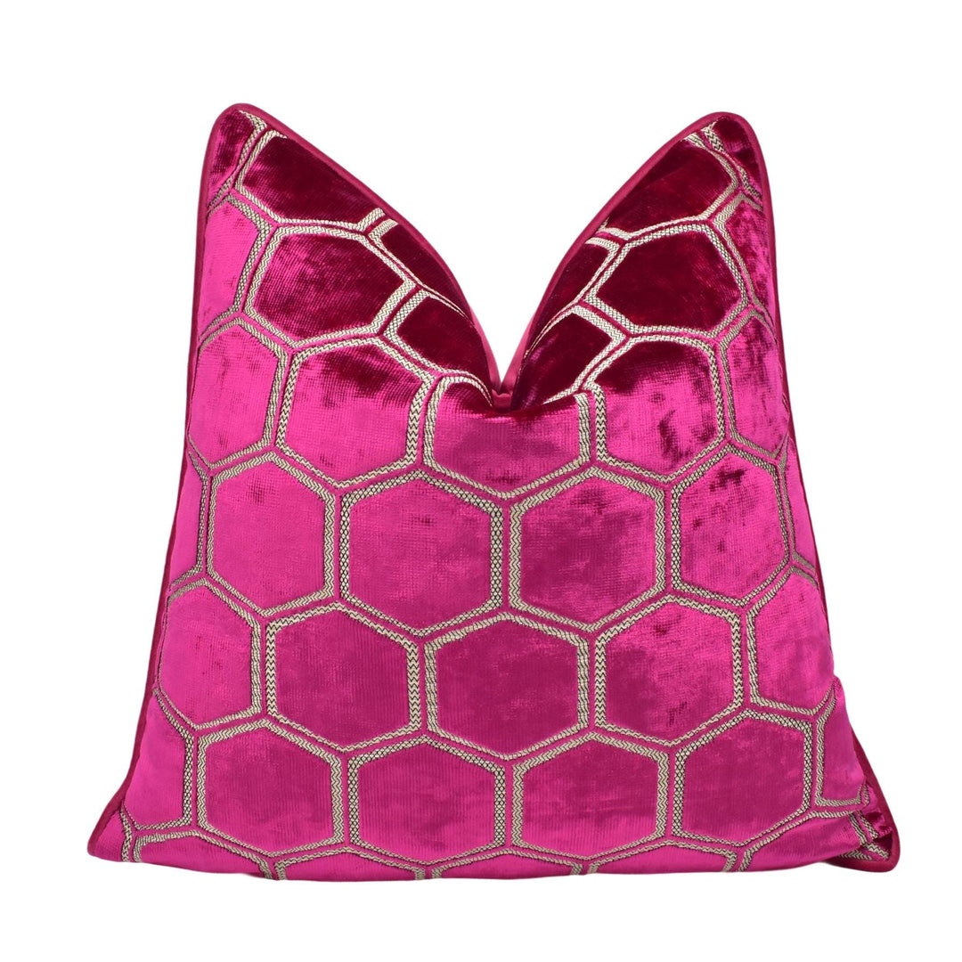 a pink velvet pillow with a geometric design