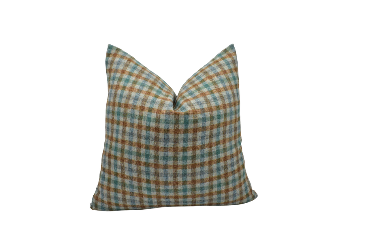 a brown and blue plaid pillow on a white background