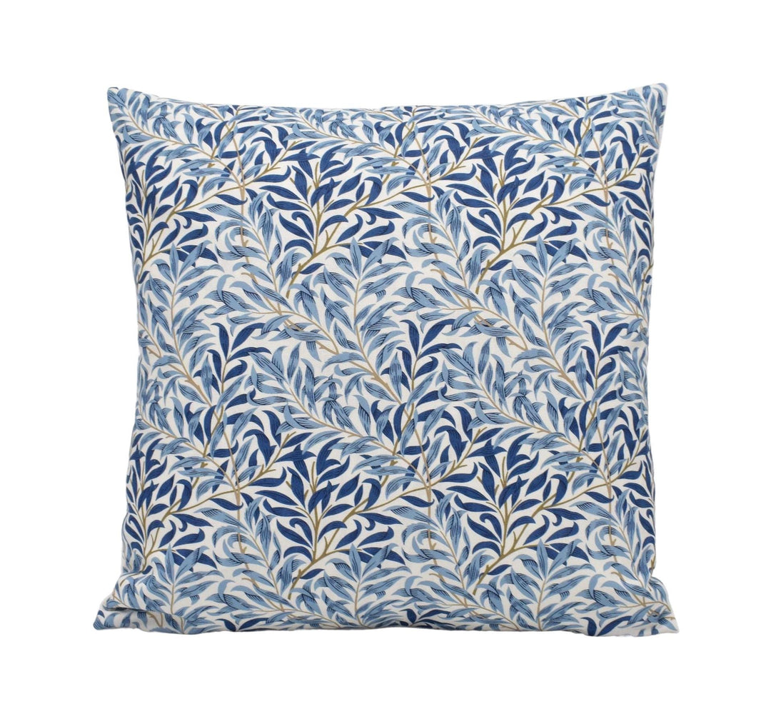 a blue and white pillow with leaves on it