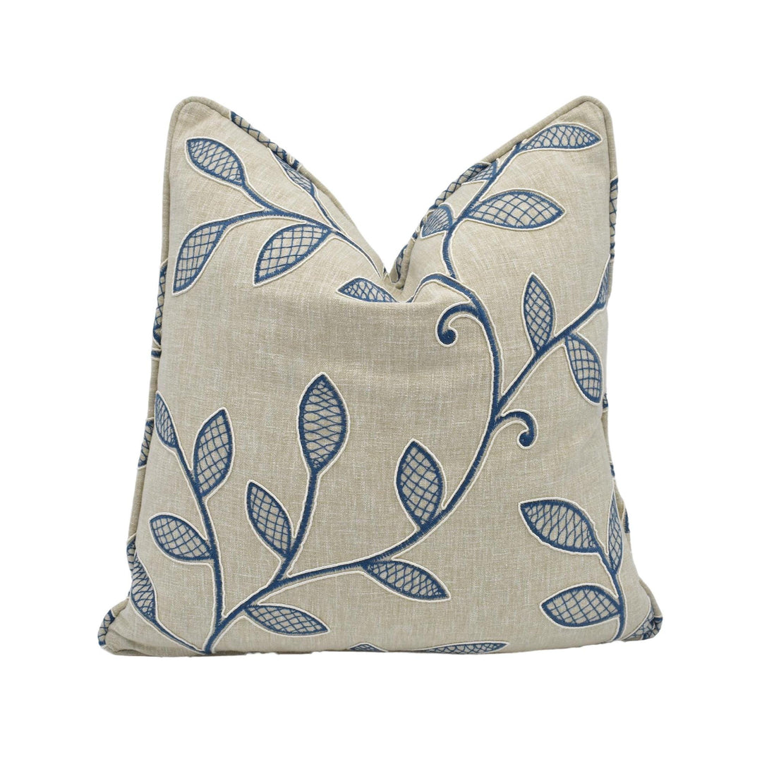 a beige pillow with a blue leaf pattern.