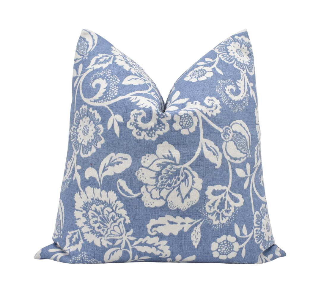 a blue pillow with white flowers on it