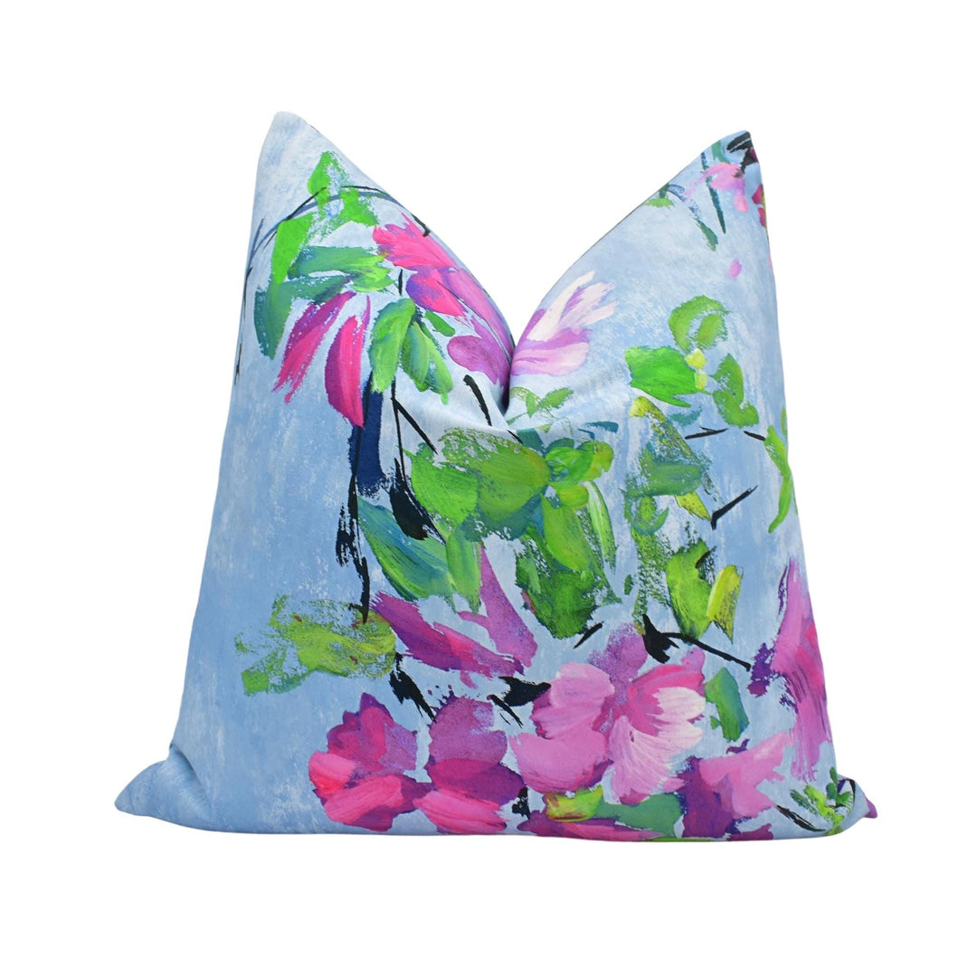 a blue pillow with pink and green flowers on it