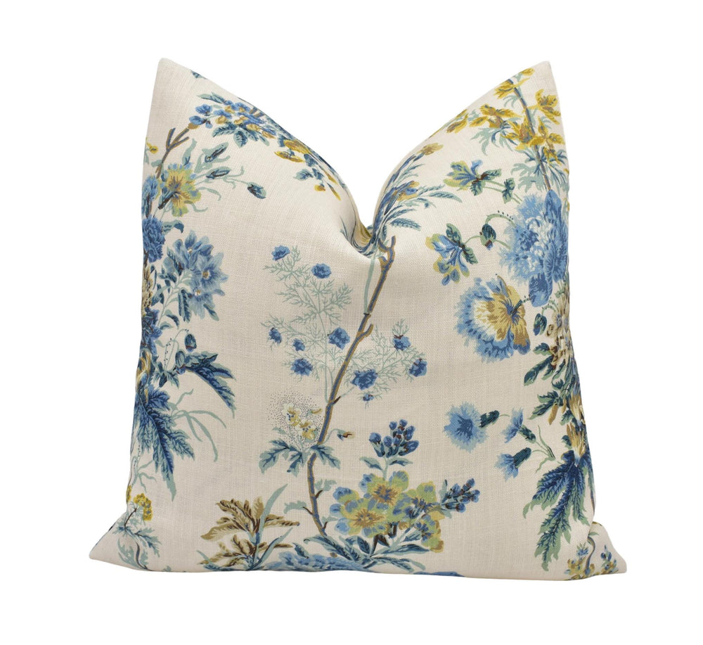 a blue and yellow floral pillow on a white background