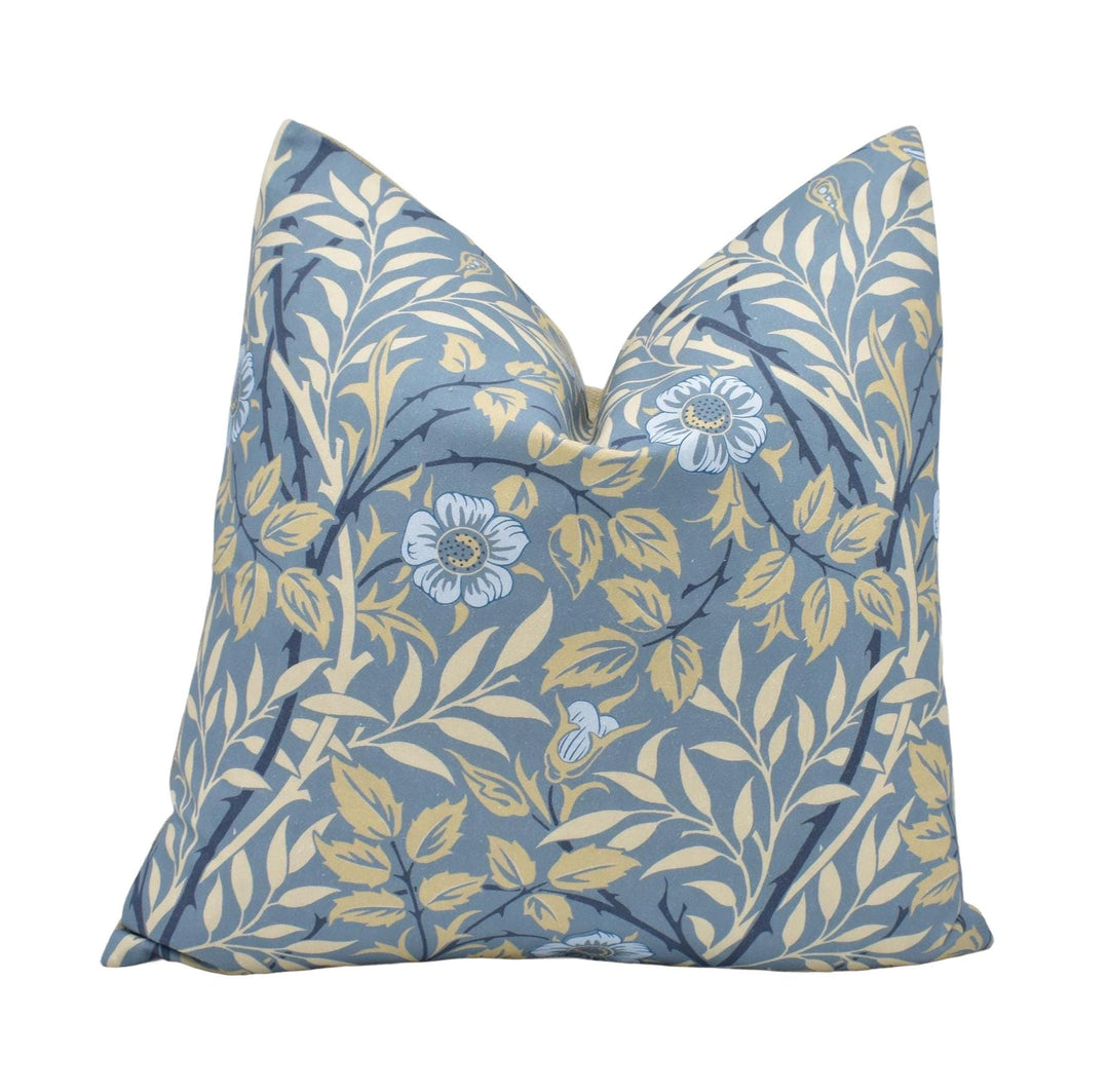 a blue pillow with yellow and blue flowers on it