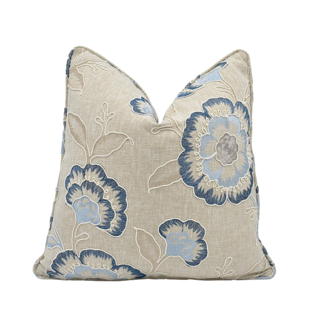 a beige pillow with a blue floral pattern.