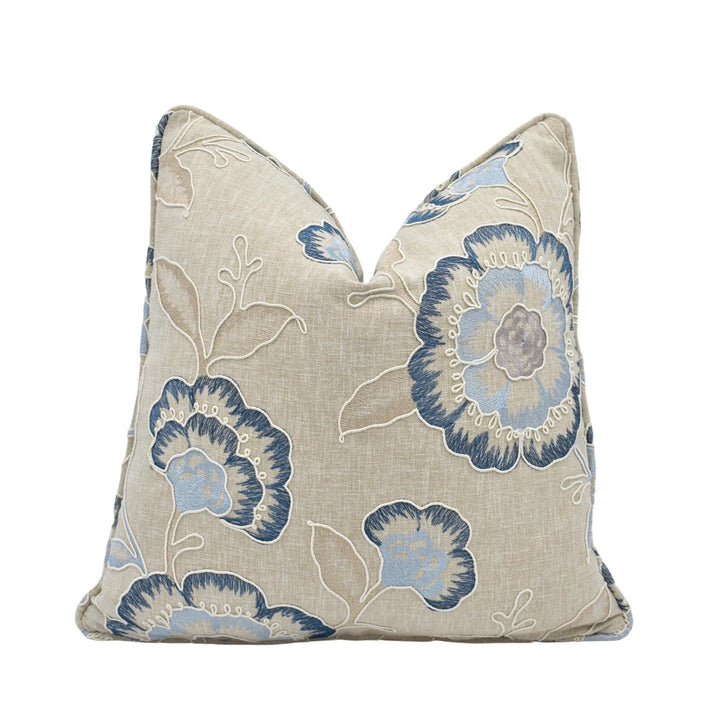 a beige pillow with a blue floral pattern.