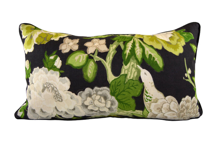 a black pillow with white flowers and green leaves