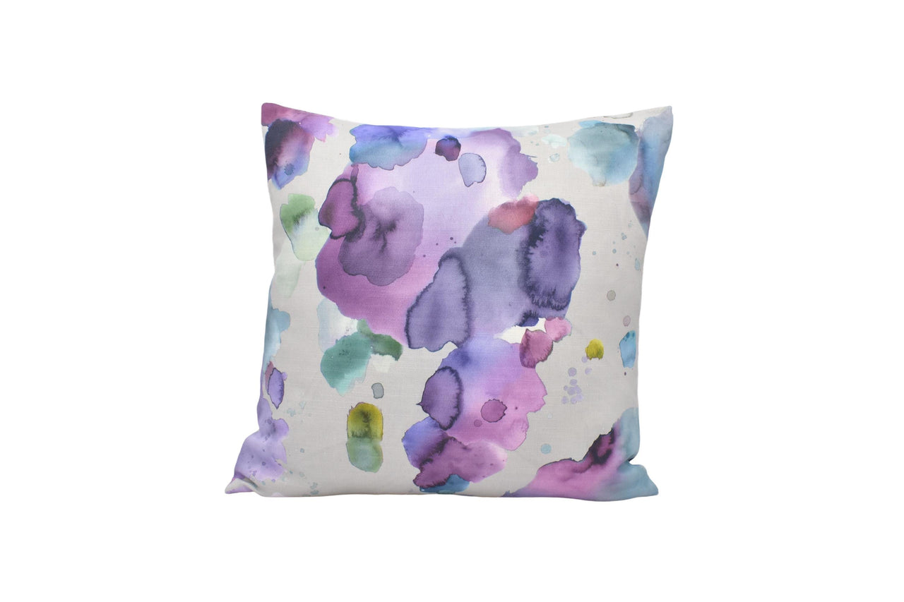 a white pillow with purple and blue flowers on it