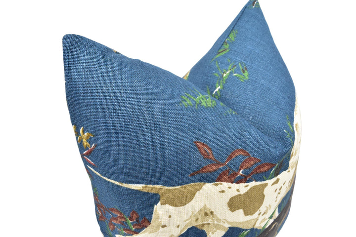 A close-up image of a blue fabric with a pattern of green and brown flowers and leaves, resembling a dog's coat.