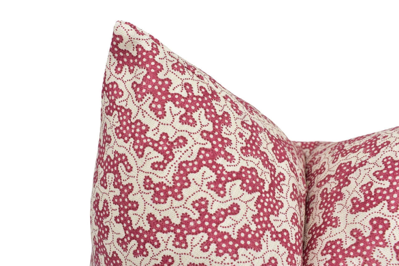 a close up of a red and white pillow on a white background