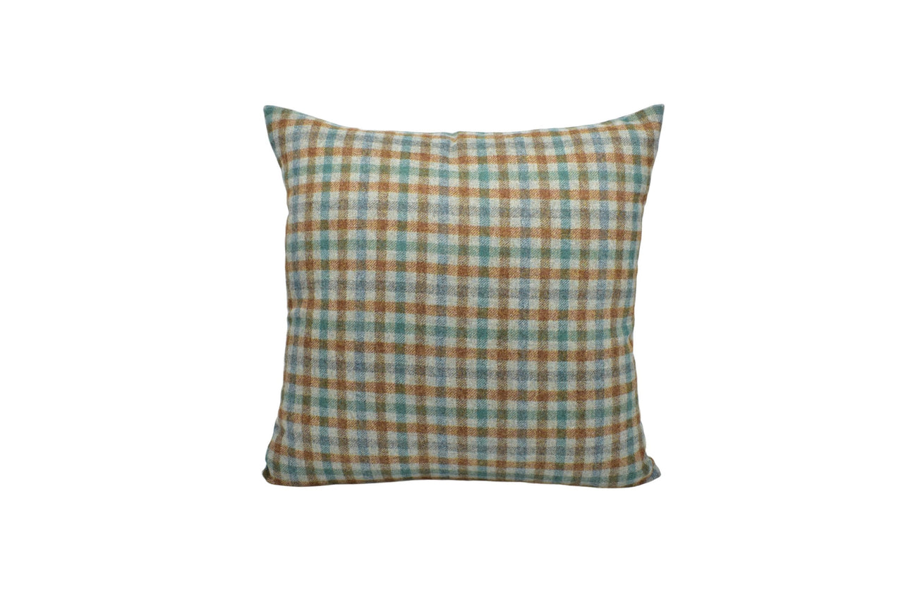 a brown and blue plaid pillow on a white background