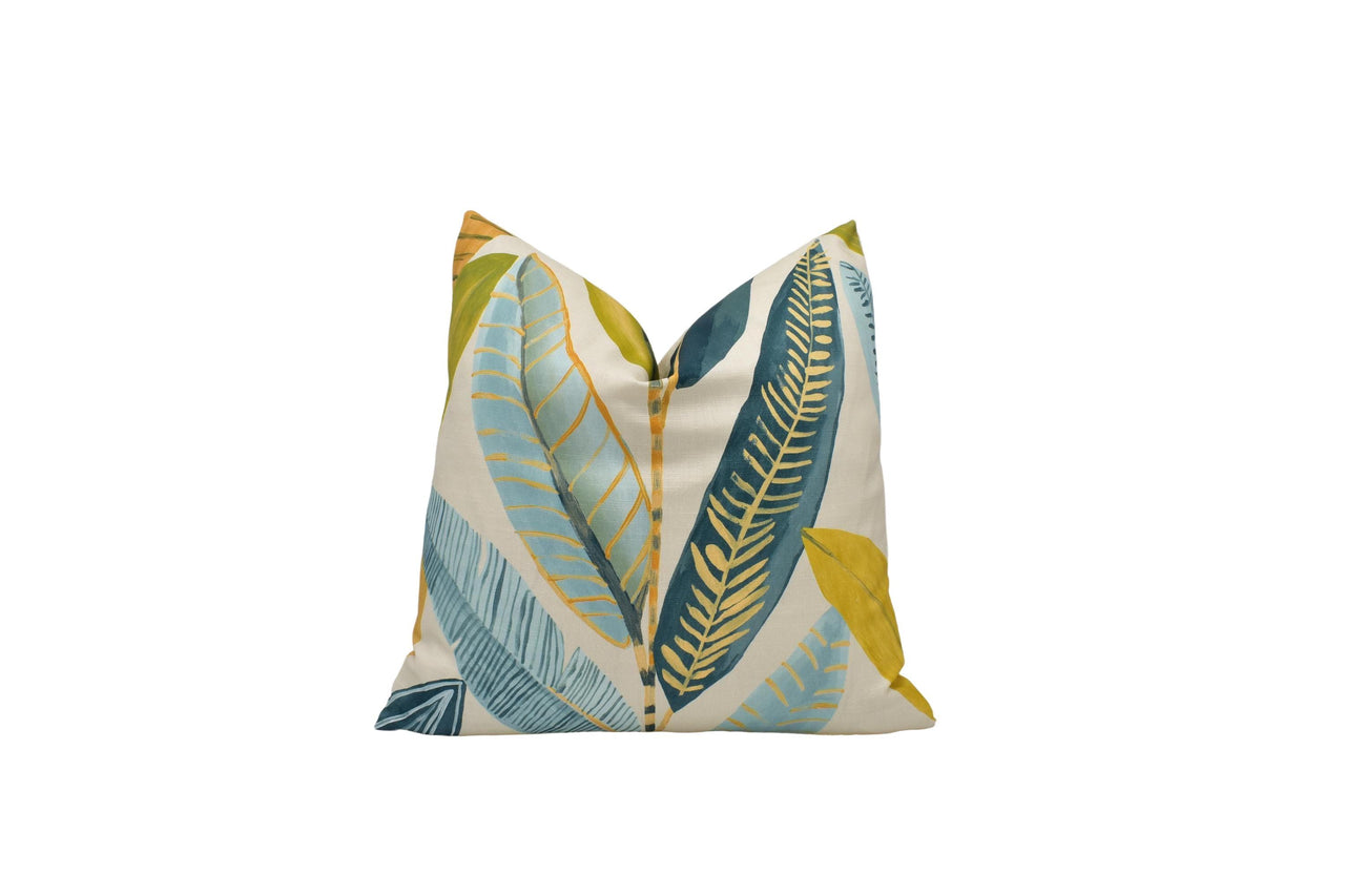 a blue and yellow pillow with leaves on it