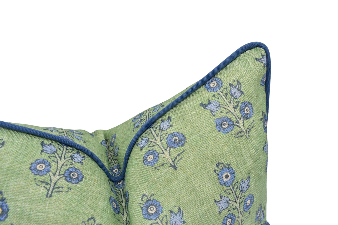 a green pillow with blue flowers on it