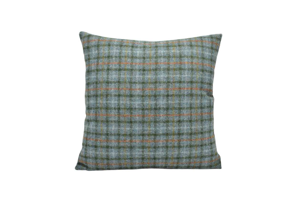 a green and orange plaid pillow on a white background