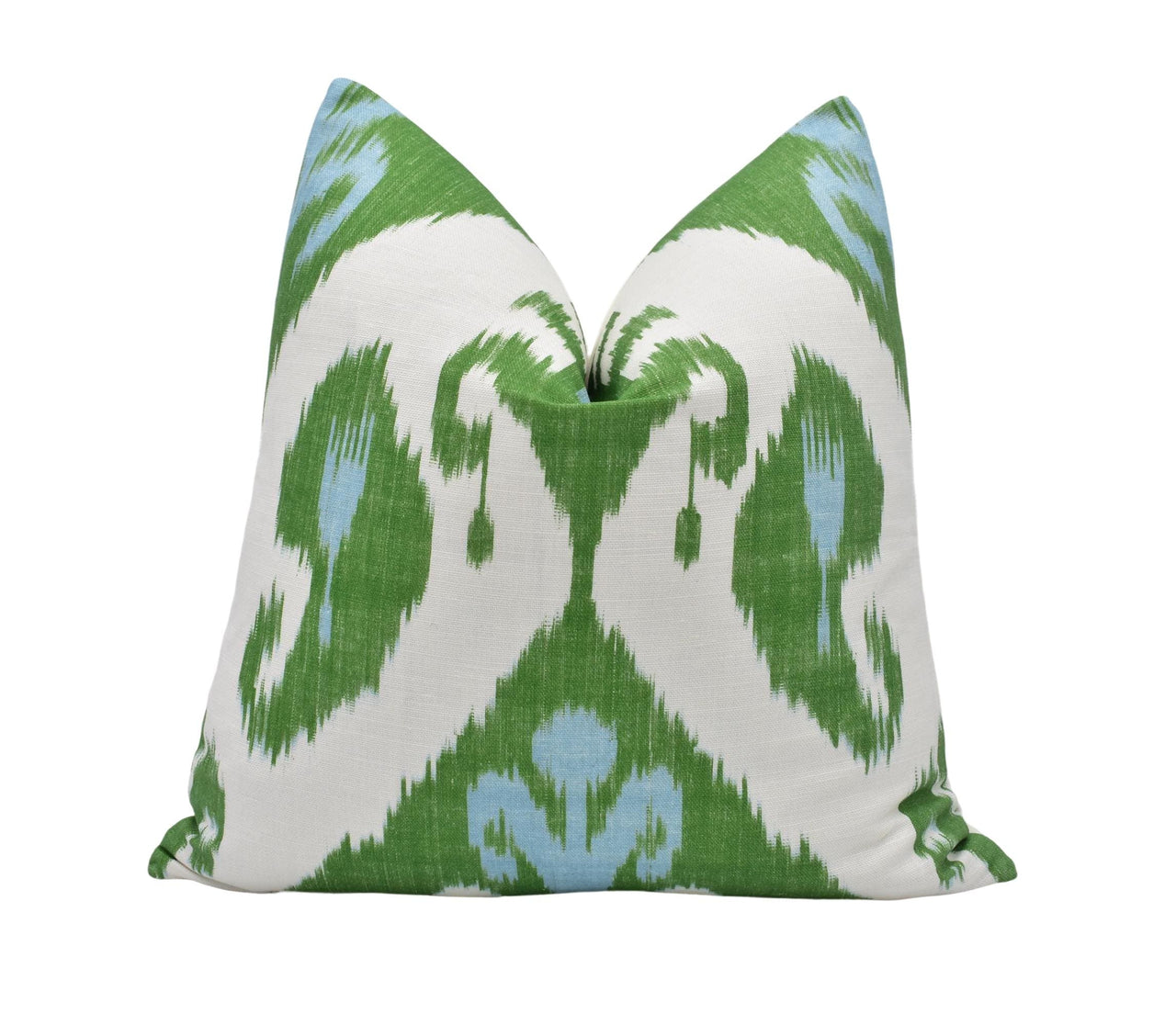 a green and white pillow on a white background