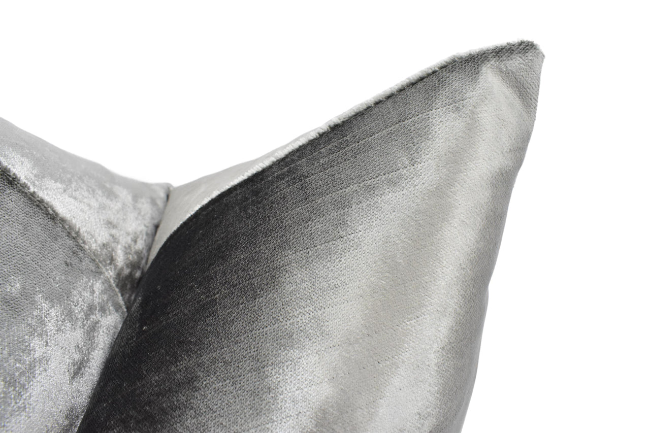 a close up of a silver pillow on a white background