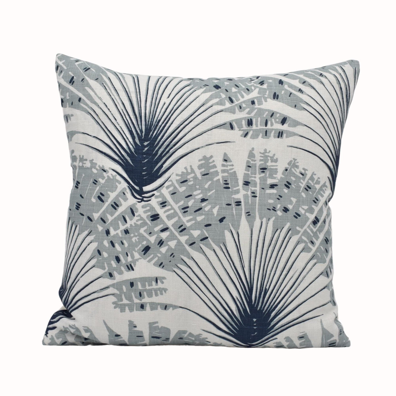 a blue and white pillow with palm leaves on it