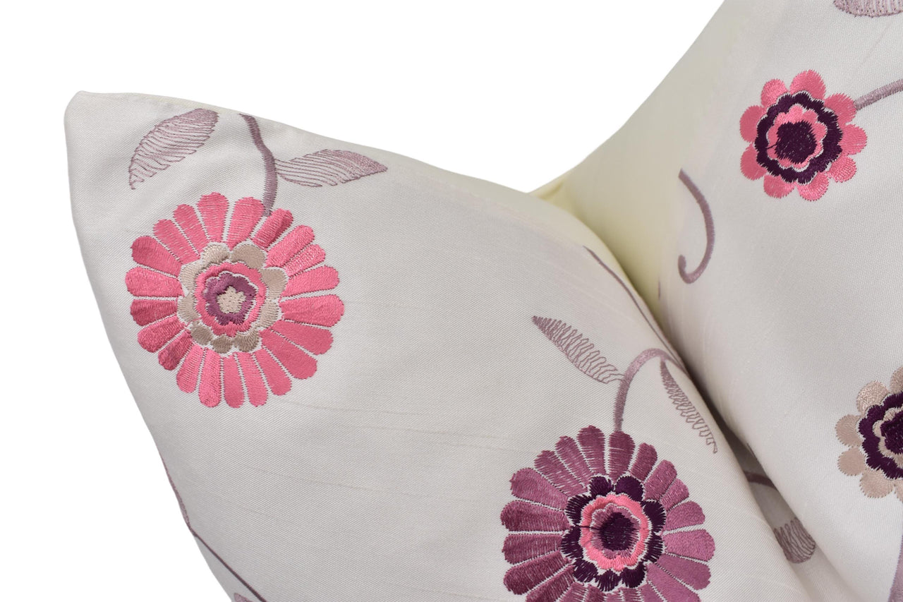 a white pillow with pink and purple flowers on it