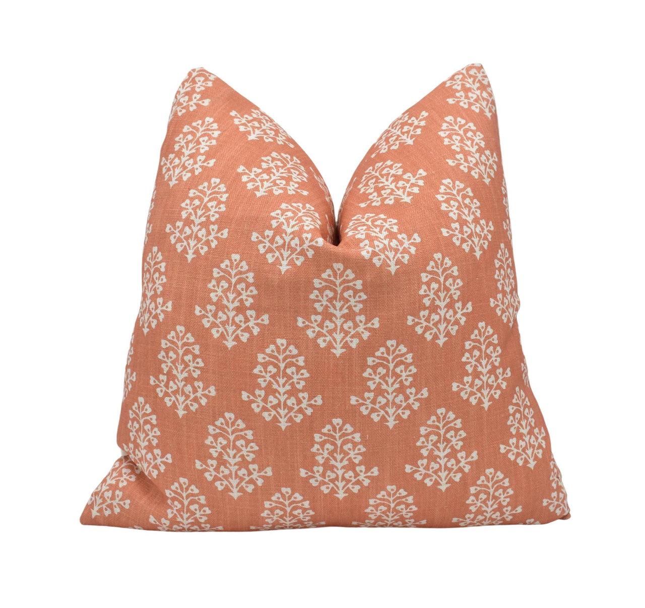 an orange pillow with white flowers on it